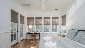 A bedroom with a bed, a desk, a chair, and a window with blinds. - Gorgeous new luxury beach house - be the first to experience this dream home! (Hilton Head)