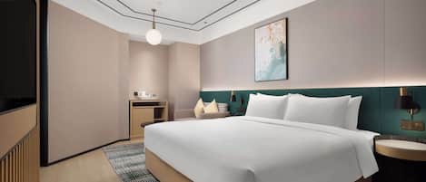 Una habitación de hotel moderna con una cama grande, un escritorio, un televisor y un cuadro en la pared.