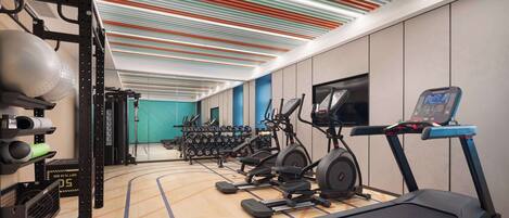 A modern gym with treadmills, elliptical machines, and weightlifting equipment.