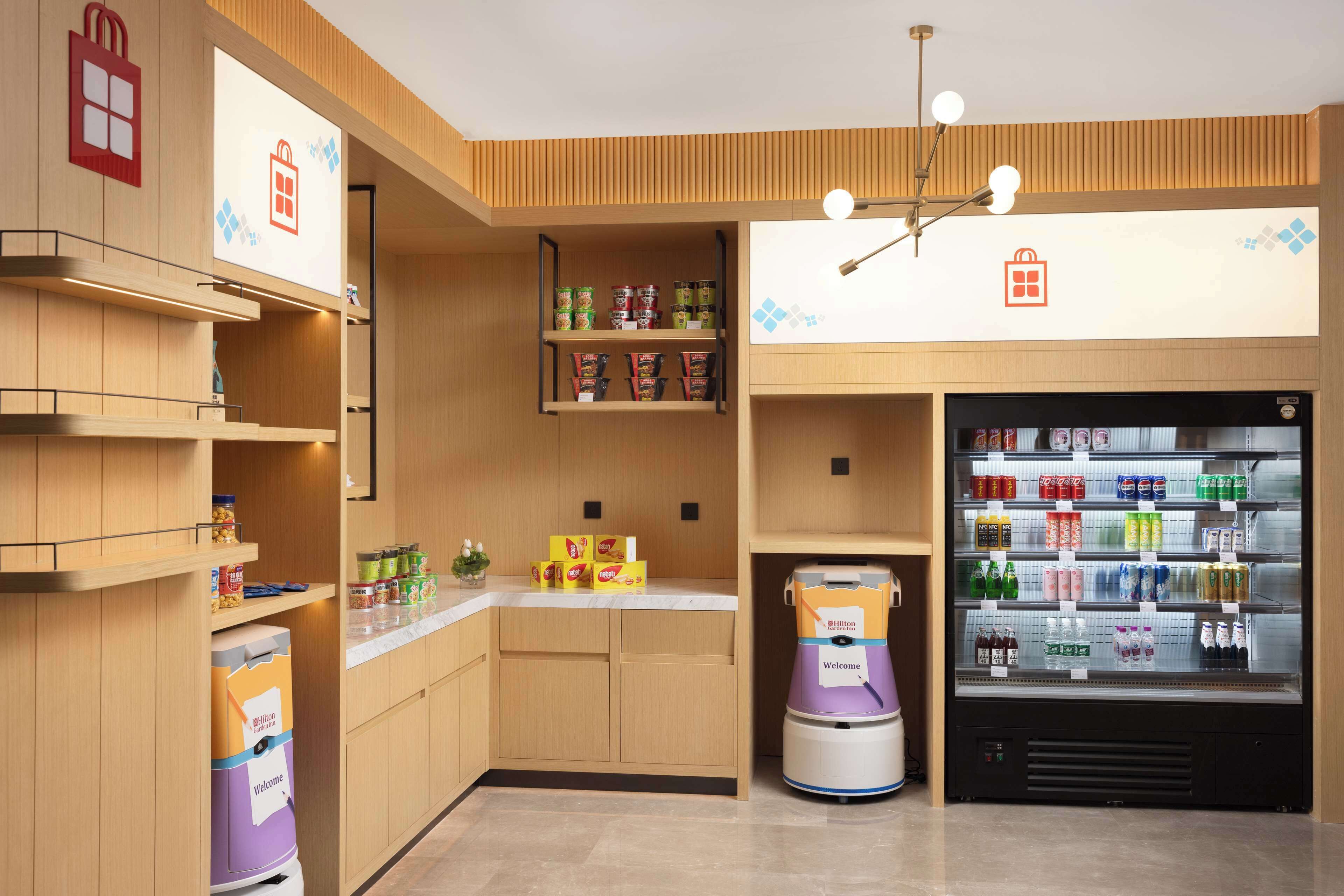 A modern kitchen with wooden cabinetry, a built-in coffee machine, and a beverage vending machine.