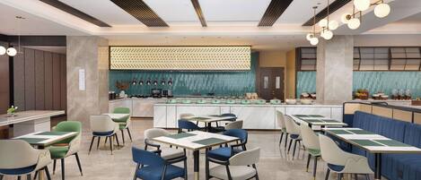 Un restaurante moderno con una isla central, varias zonas de estar y un diseño contemporáneo en el techo.