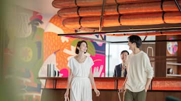 A reception area with a colorful mural, a reception desk, and a modern ceiling design.