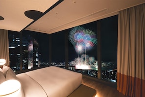Une chambre d’hôtel moderne avec un grand lit, une vue sur la ville et une fenêtre avec des rideaux.