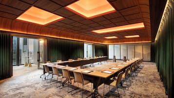A conference room with a long table, chairs, and a modern ceiling design.