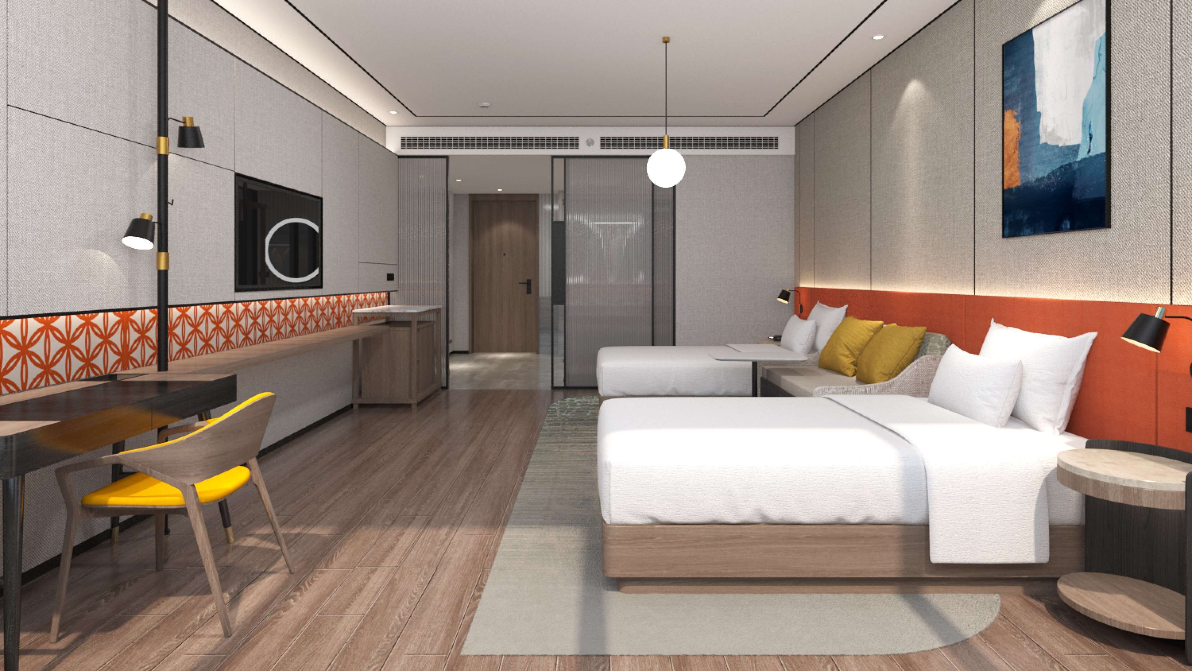 A modern hotel room with a wooden floor, a desk with a chair, a bed with pillows, a bedside table, and a wall-mounted artwork.