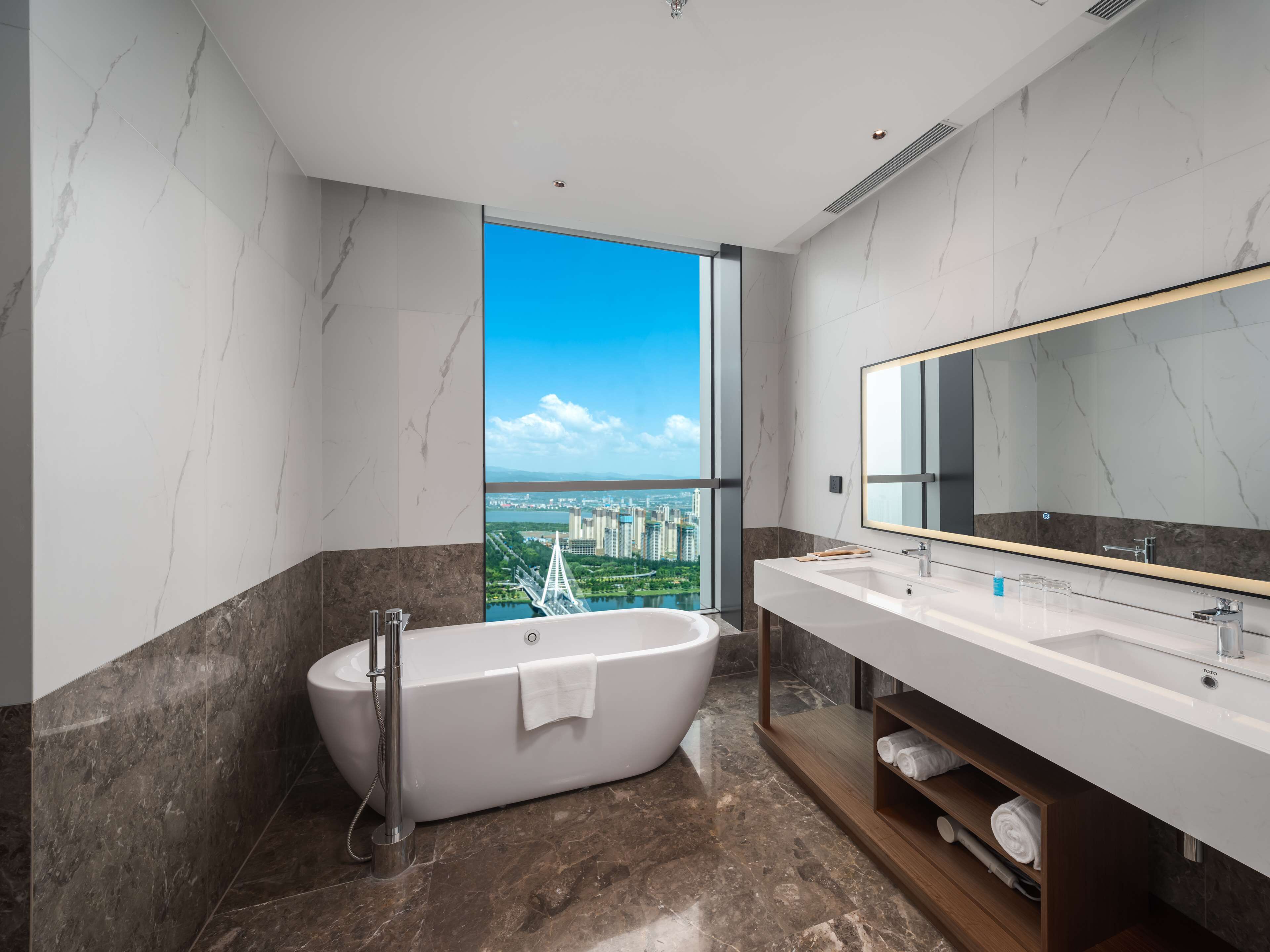 Une salle de bain moderne avec une baignoire sur pieds, un grand miroir et un meuble-lavabo.