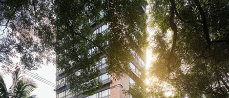 A multi-story building with a modern architectural design, featuring large windows and a brick facade.