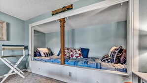 A cozy room with a built-in bed, a cat tree, and a small table. - Castaway - Family-friendly with a dog in protected cove (Huddleston)