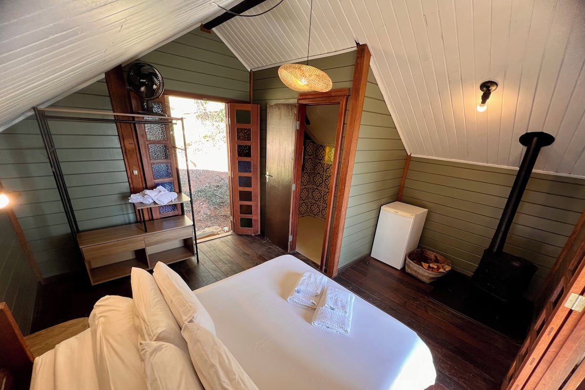 Une chambre confortable avec un lit, une petite table, un radiateur et une fenêtre donnant sur l’extérieur.