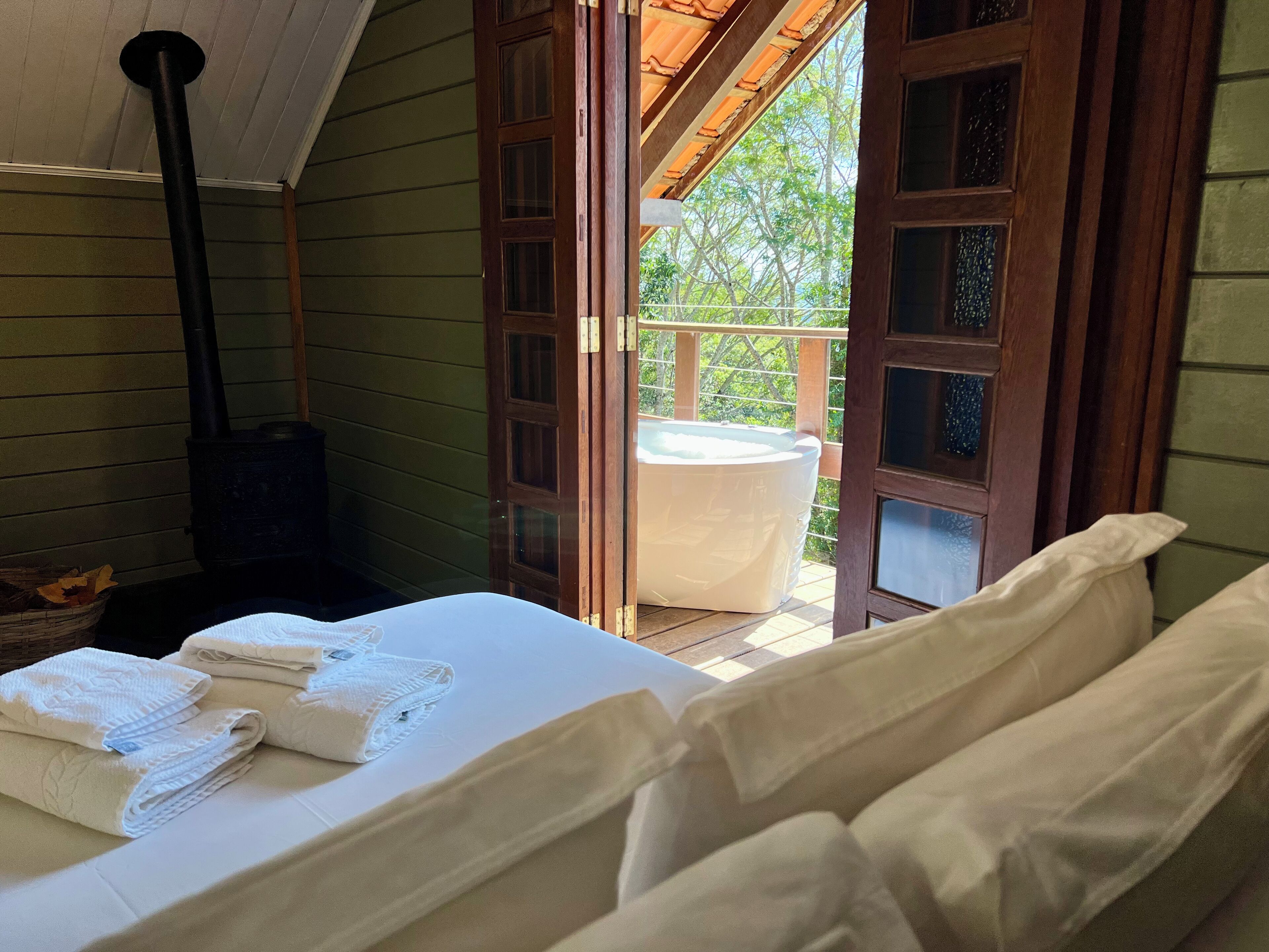 Una habitación acogedora con cama, jacuzzi y chimenea.