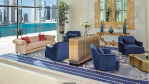 A spacious room with a large window offering a city view, a grand mirror, and modern furniture. - Vogue | DAMAC Maison Privé | Near Dubai Mall (Dubai)