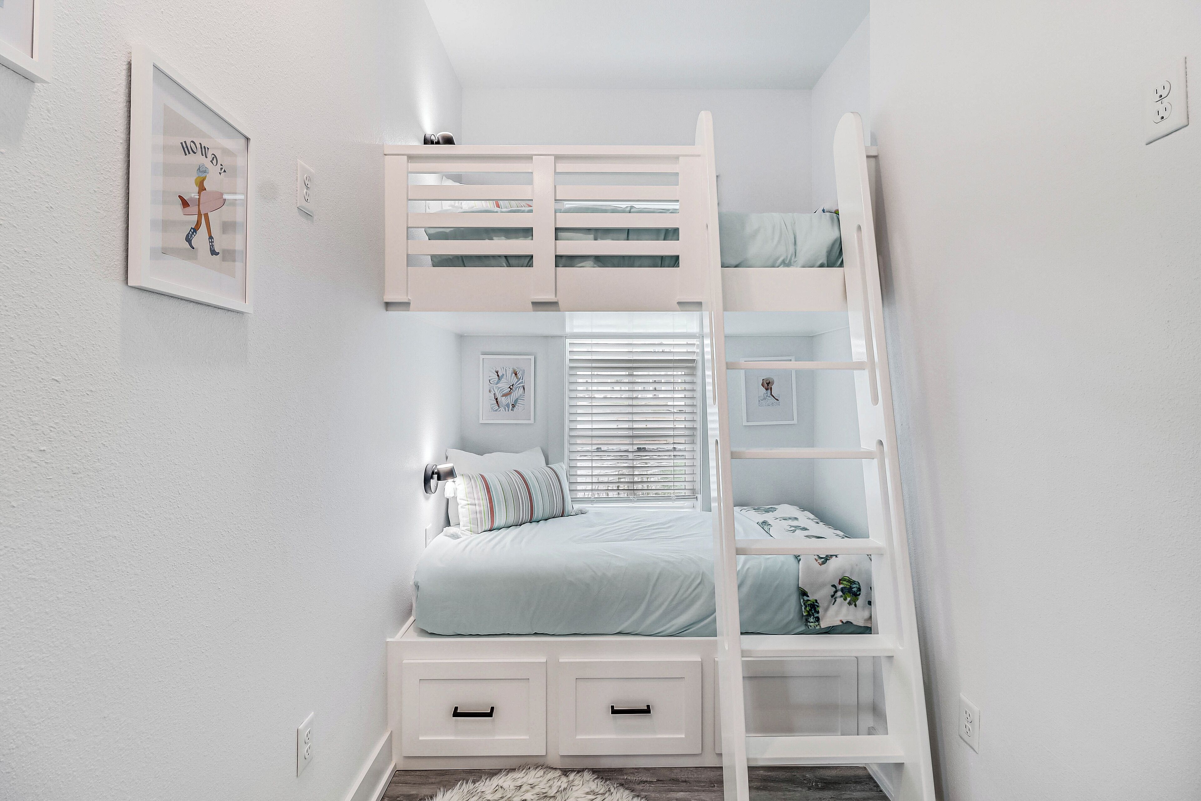 Una cama individual superpuesta con escalera, una mesita de noche y una ventana con persianas.