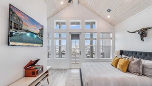 Une chambre avec un grand lit, un téléviseur fixé au mur et une décoration représentant un crâne de taureau.
