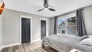 A bedroom with a bed, a ceiling fan, a window with curtains, and a door. - 6 BR, 4BA Franklin, IN Home (Franklin)
