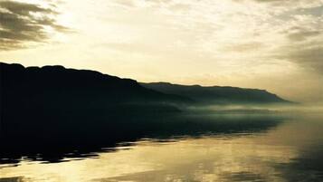 Ein ruhiger See mit Bergen im Hintergrund.