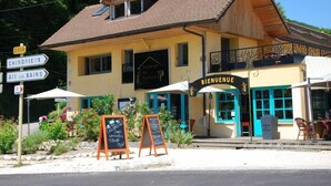 A building with a sign reading "Bienvenue" and a signpost indicating directions to "Chindrieux" and "Aix les Bains". - Auberge de Portout (Chanaz)
