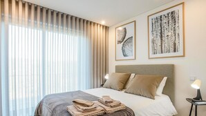 A modern hotel room with a large bed, a nightstand with a lamp, and artwork on the walls. - Casa do Barbeiro | Pool | River Minho Views | Agro-tourism (Melgaço)
