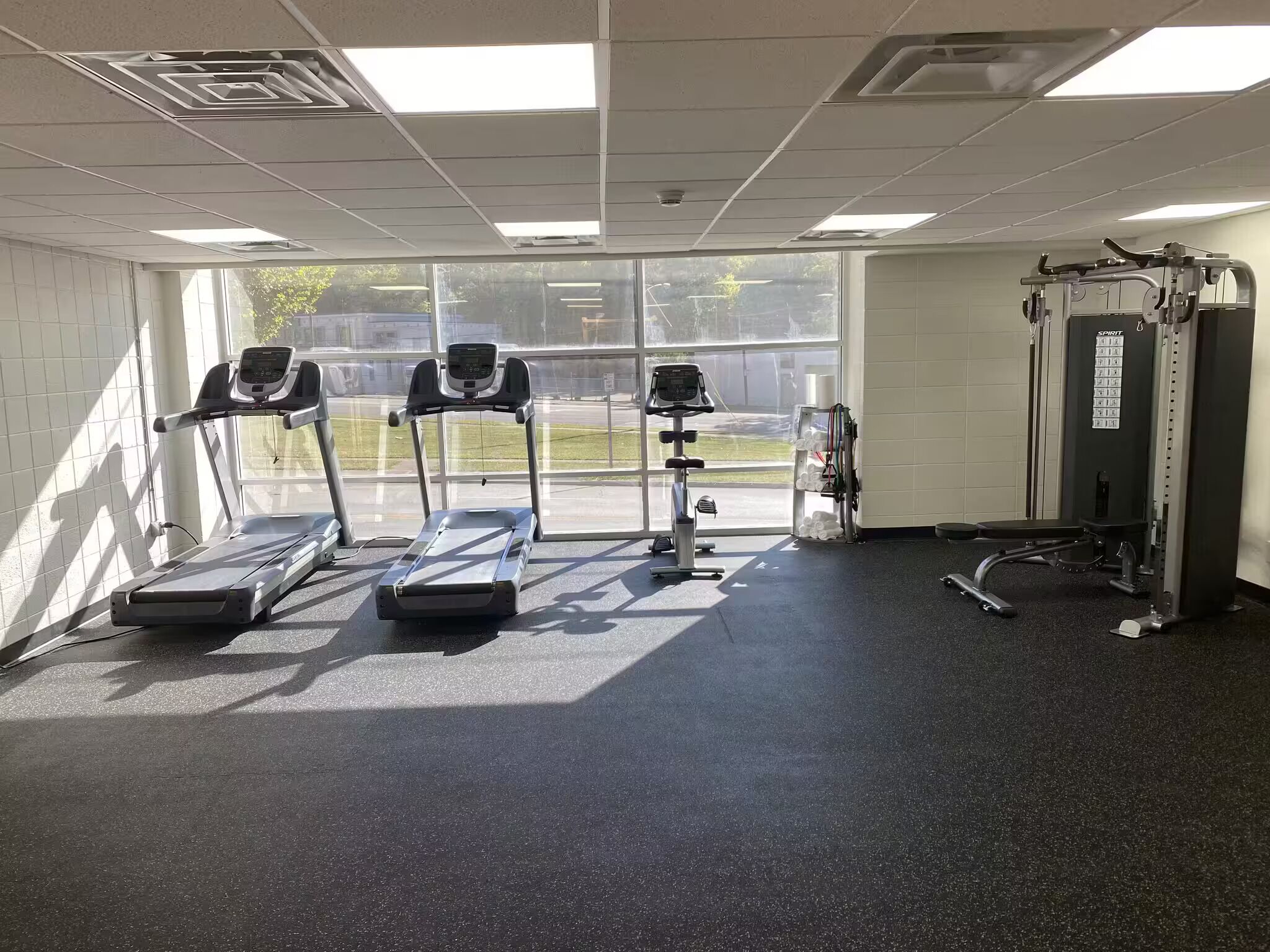 Una palestra con tapis roulant, cyclette e attrezzature per sollevamento pesi.