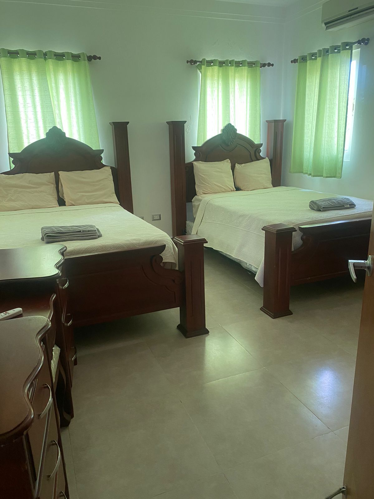Ein Hotelzimmer mit zwei hölzernen Betten, einem Schreibtisch aus Holz und einem Stuhl.
