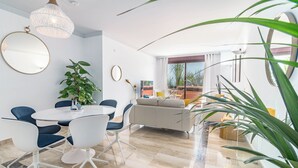 A modern living room with a dining area, a large potted plant, and a balcony with a view. - Luxury and spacious 3-bed Penthouse apartment in fabulous Gualdalmansa (Gualdalmansa)