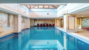 An indoor swimming pool with a high ceiling, red chairs, and classical wall murals. - Luxury and spacious 3-bed Penthouse apartment in fabulous Gualdalmansa (Gualdalmansa)