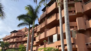 A multi-story hotel with balconies, palm trees, and a garden area. - Luxury and spacious 3-bed Penthouse apartment in fabulous Gualdalmansa (Gualdalmansa)