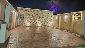 A building with a stone facade, a gated entrance, and a sign indicating a restaurant. - Departamentos Chan Kiin (Valladolid)