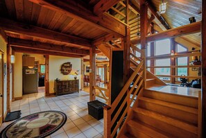 Un intérieur spacieux avec un escalier en bois, un coin cuisine et un espace repas.