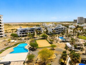 A resort with multiple buildings, a swimming pool, and a tennis court.