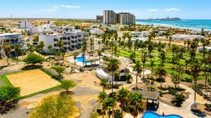 Un complexe hôtelier comprenant plusieurs bâtiments, un espace piscine et offrant une vue sur la plage.