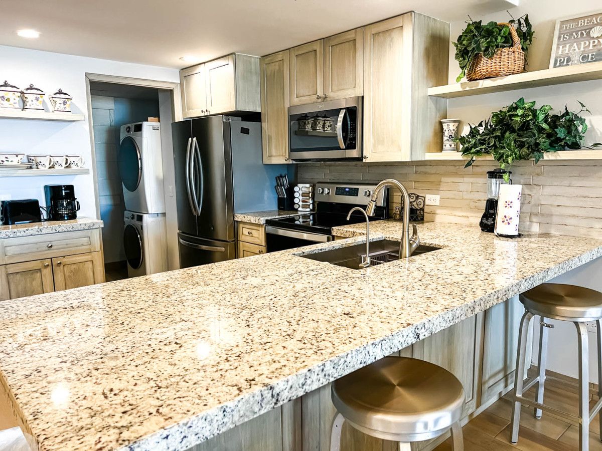 A modern kitchen with granite countertops, stainless steel appliances, and wooden cabinets.