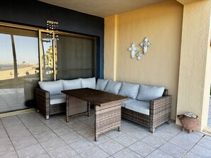 A balcony with wicker furniture, a table, and decorative items.
