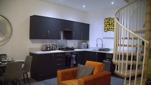 A compact living space with a kitchenette, a dining area, and a small sofa. - Old Dutch Embassy by Guestz (Kingston-upon-Hull)