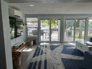 Cozinha moderna com forno embutido, uma janela grande e vista para a área do pátio externo.