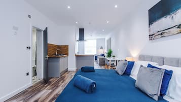 Una habitación de hotel moderna con una cama grande, un escritorio y una kitchenette.
