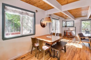 Enjoy meals in this spacious dining area with a large table and comfortable chairs, surrounded by natural views.