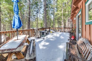 Enjoy outdoor dining and relaxation on this secluded deck surrounded by tall pine trees.