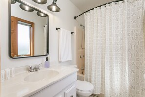 A bathroom with a white sink, mirror, and towel rack. - Relaxing Lakeview Retreat! Pool, Hot Tub, Firepit, Gameroom Perfect for Groups,  (Penn Yan)