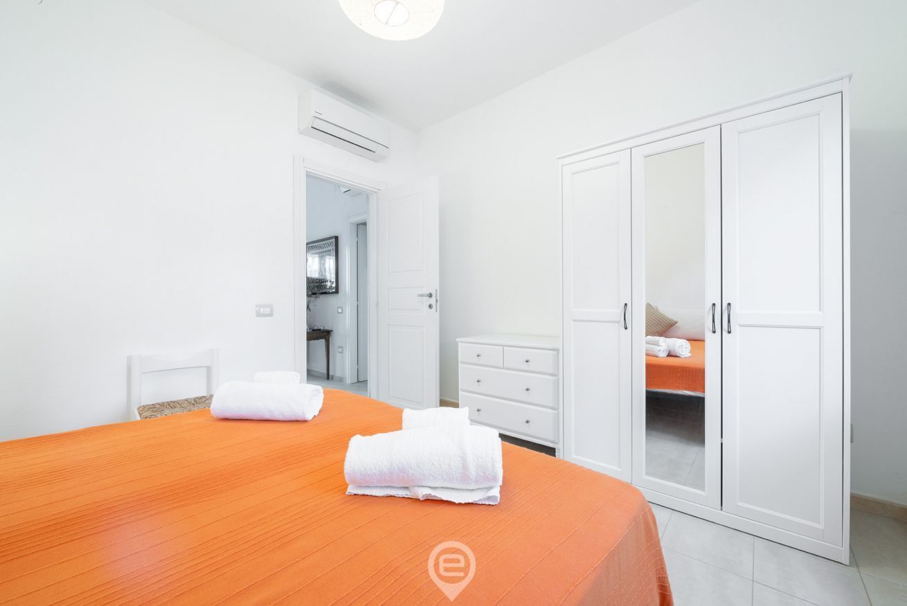 Ein Hotelzimmer mit einem großen Bett, einem Schrank und einem durch eine offene Tür einsehbarer Badezimmer.