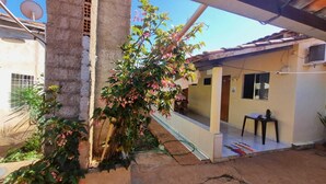 A courtyard with a concrete pillar, a small table, and a chair. - MATEUS ALVES DA SILVA (São João da Paraúna)