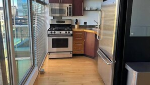 A compact kitchen with a stove, microwave, oven, and refrigerator.