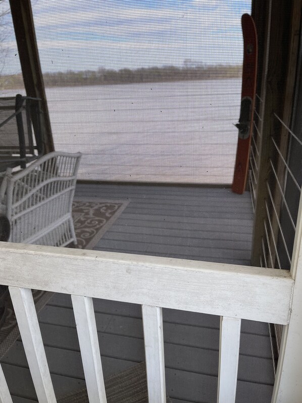 Een witte metalen balustrade met een gaas, onderdeel van een gevel.