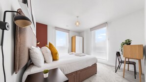 A modern bedroom with a large bed, bedside tables, a desk, and a chair. - SERCASA - Regents Park (London)
