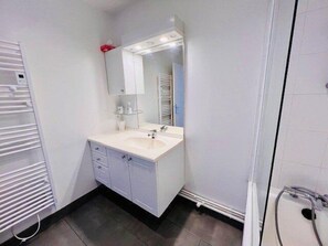 Enjoy a refreshing shower in this bathroom featuring a spacious vanity and large mirror.