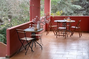 A patio with a round table and chairs, a vase with flowers, and a bench. - Villa Dan  (Monopoli)