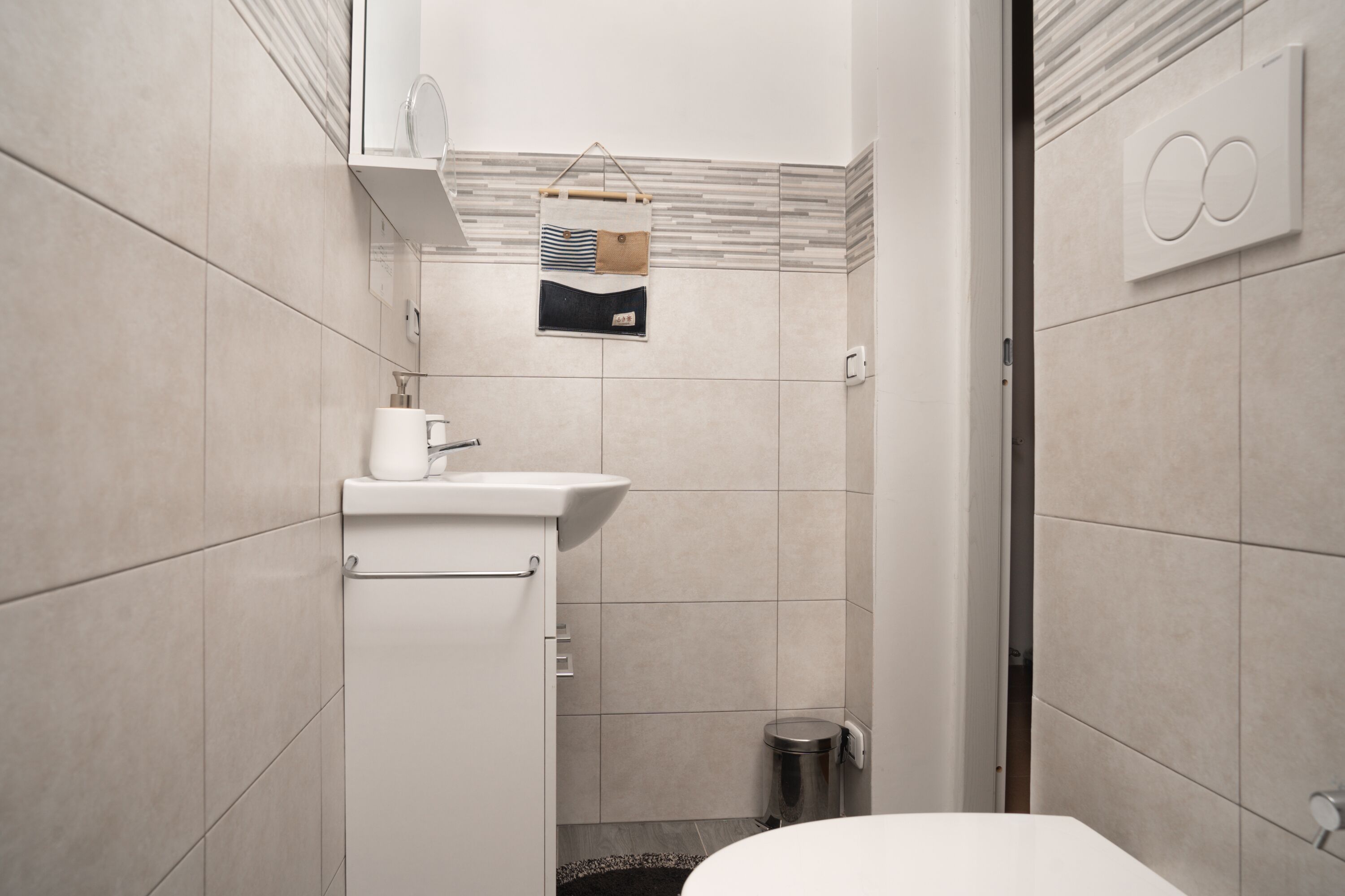 A modern bathroom with a toilet, sink, and shower area.