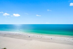 A beach with clear turquoise water and a sandy shore.
