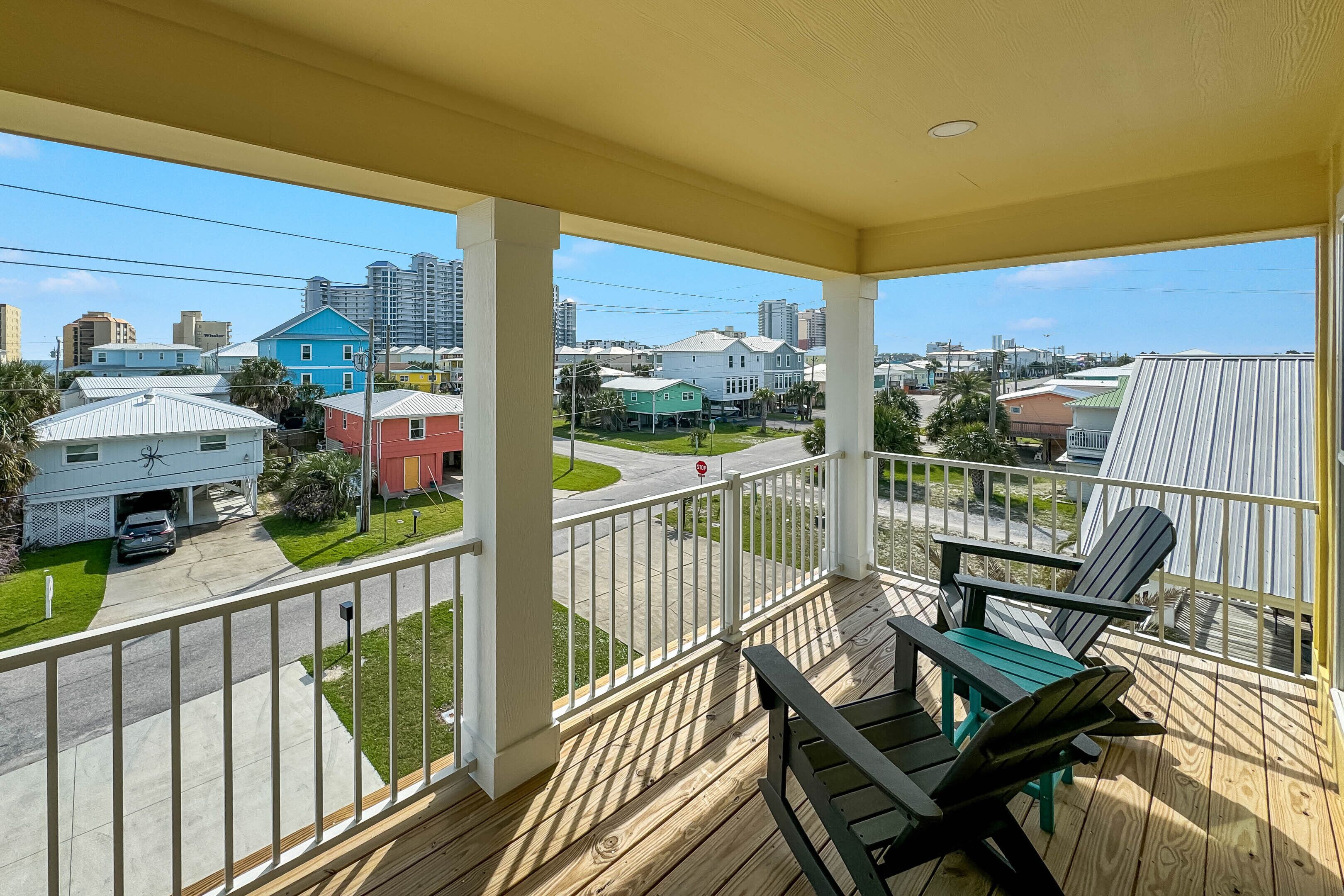 Une terrasse en bois offrant une vue sur un quartier résidentiel, avec des maisons et une route.