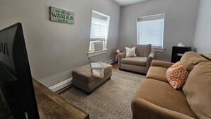 A living room with a television, two sofas, a coffee table, and a rug. - Alice Pet-Friendly Downtown Newport Rental with Parking  (Newport)