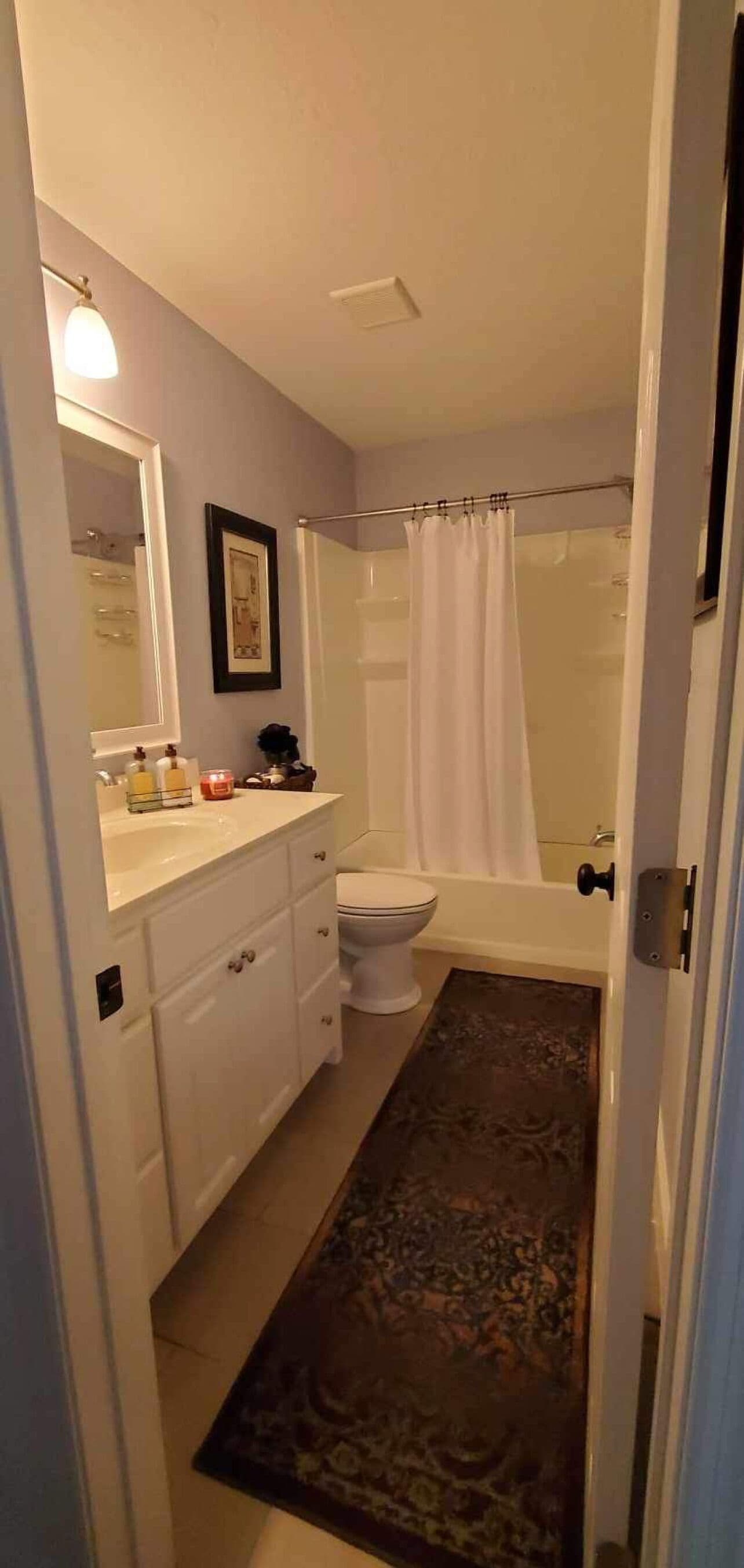Une salle de bain avec des toilettes, un lavabo et une douche.